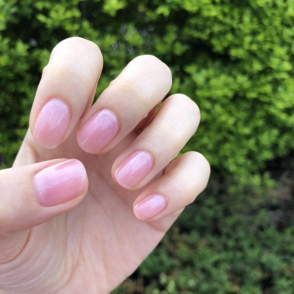 Glossy pale pink manicure outdoors